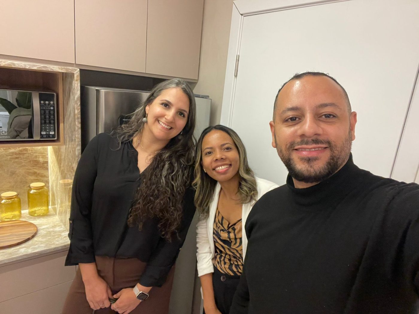 Equipe da NID na cozinha do apartamento decorado entregue